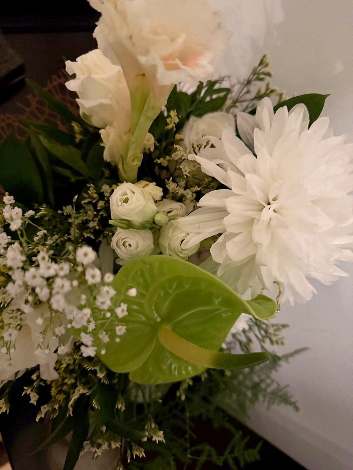 Hvid buket med krysantemum, ranunkler og grøn anthurium fra receptionen
